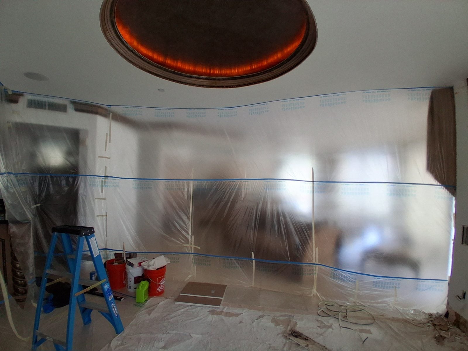 Plastic sheeting taped across a room to keep dust in the work area