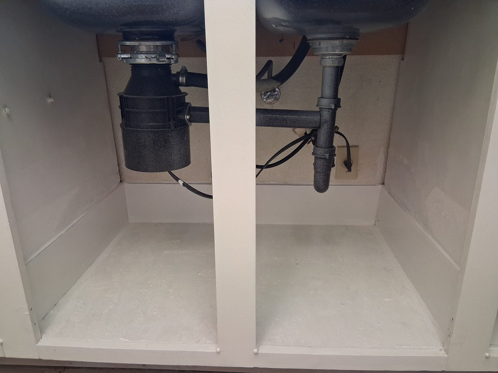 Same sink base with a new floor panel, plumbing back in place