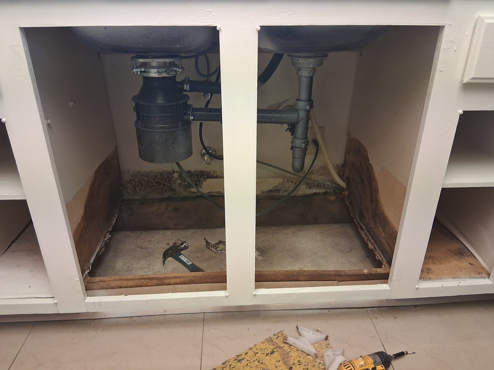 Kitchen sink base with the floor rotted out by a slow leak